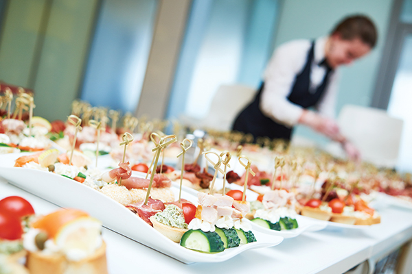 a waitress putting out a finger food buffet catered for a party
